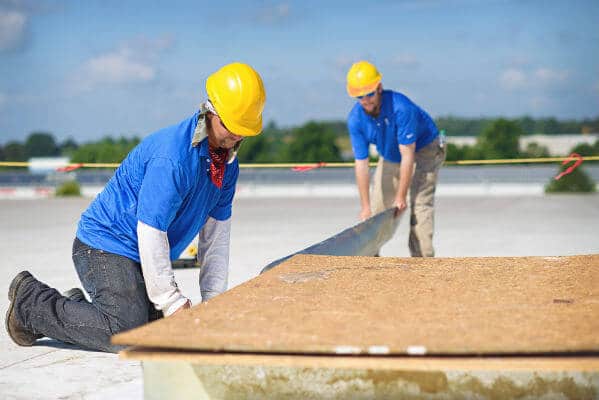 Mid-South Roof Systems Team Members atop a roof working on commercial roof HVAC