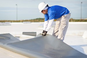 Mid-South Roof Systems Team Members atop a roof working on flat roof material