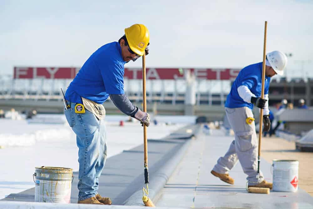 Mid-South Roof Systems Team Members atop a roof working on fully adhered roof application