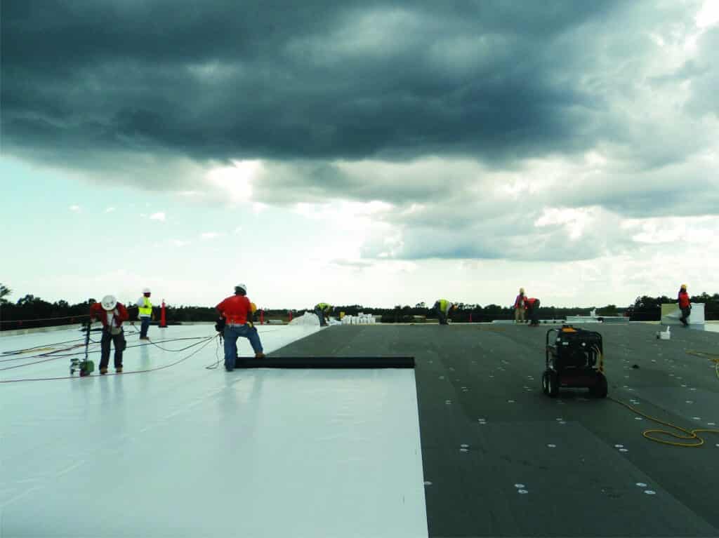 Mid-South Roof Systems Team Members atop a roof working on water damage