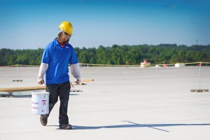 Mid-South Roof Systems worker carrying bucket, commercial roof warranties