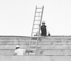 Mid-South Roof Systems Team Members atop a roof with a ladder, smiling