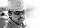 Close-up headshot of Mid-South Roof Systems Safety Team member wearing "Joint the Safety Team" hard hat and sunglasses