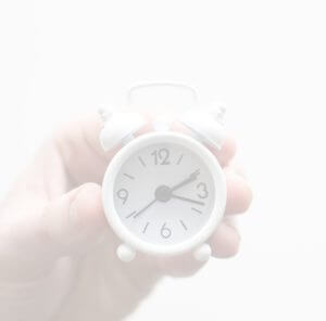 hand holding tiny alarm clock